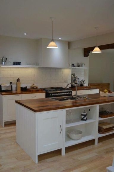 Kitchen island with iroko worktops and a undermounted stainless steel sink, drainer grooves have been cut into the worktop.