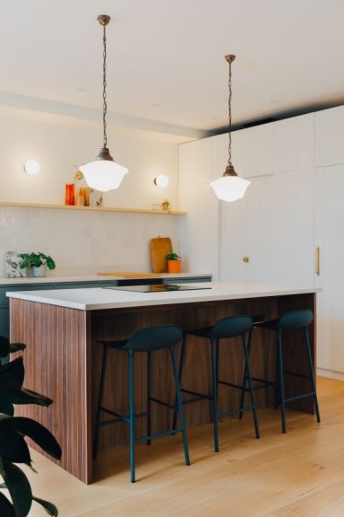 A well lit bespoke kitchen Island with seating.