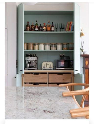 Open kitchen pantry with coffee making station and vegetable storage drawers.