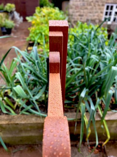 Hardwood gates with water beading on the surface of them, finished with Osmo wood stain.