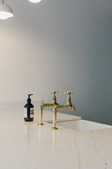A marble kitchen worktop, Belfast sink, Perrin Rowe brass taps and Aesop's hand wash.