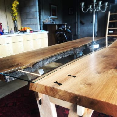 Custom hardwood river table made in Sheffield with glass and bow ties in ebony to fix cracks. Handmade bespoke table.