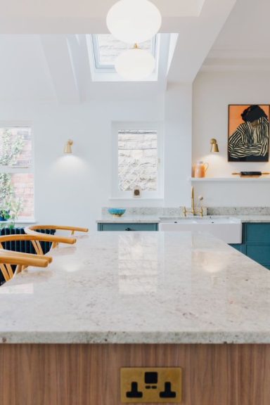 A custom kitchen island with brass sockets fitted into the end panels.
