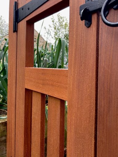Custom Sapele garden gates in Derbyshire with black hardware.