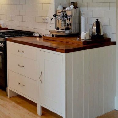 Farrow and Ball All white shaker kitchen with open plinths and Iroko hardwood worktops.